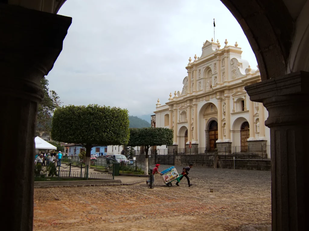Dos niños empujando un carrito de granizada delante de la catedral de Antigua Guatemala