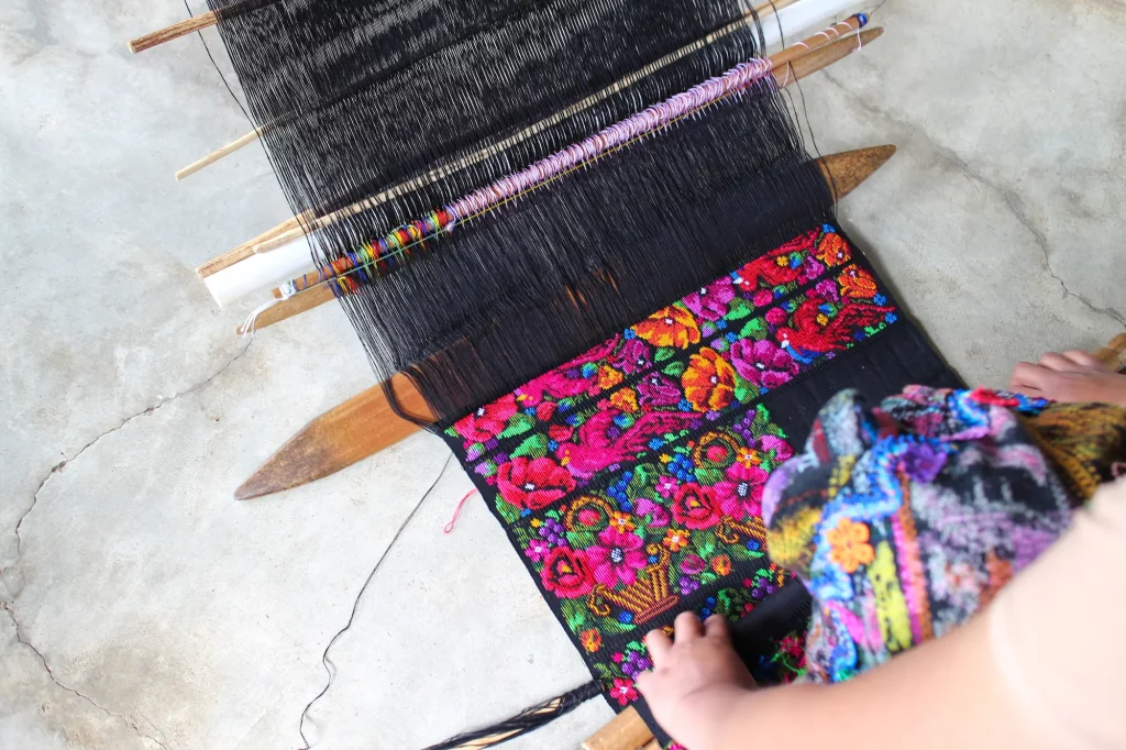 Weaving in progress on a back strap loom of a Güipil in the "cruz" style