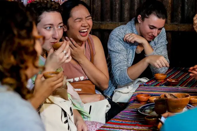 Viajeros riendo alrededor de una mesa durante un tour de comida en Antigua Guatemala