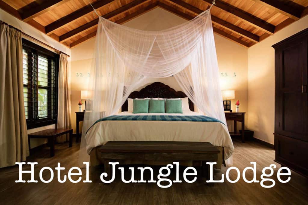 La Suite Jungla del Hotel Jungle Lodge de Tikal muestra una cama cubierta con una elegante mosquitera y una colcha con detalles de tela típica guatemalteca